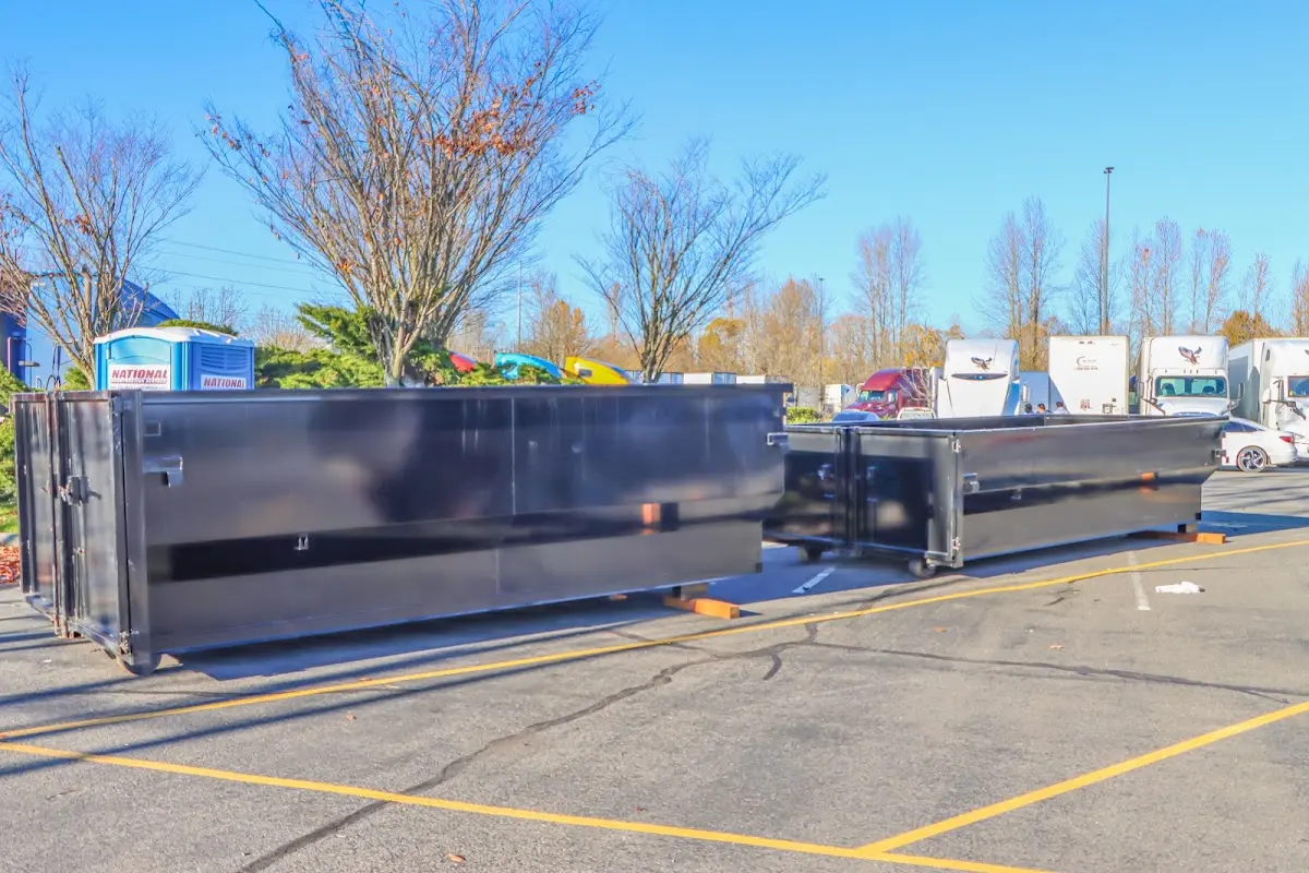 Professional dumpster rental service with roll-off container on residential driveway in Columbia Falls
